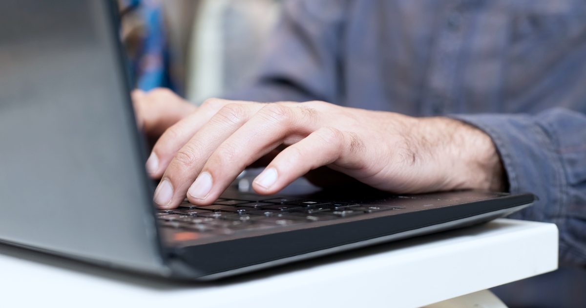 Professionnel rédigeant des instructions IA sur son ordinateur